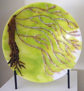 Spring: Cherry Tree Large Bowl (16" diameter), features streaky spring green and clear glass fused to a white base for the background. The trunk of the tree is glass rods twisted with torch-work and tack-fused to maintain texture. The branches are slumped stringers layered with frit powders in clear, petal pink, and ruby red tint. This piece endured three kiln-firings before it was ready for the fourth and final slumping phase in the kiln.